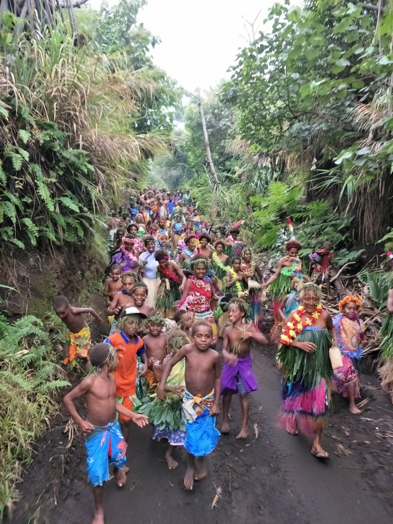 a community dancing in front of motocade to entrance of Friendly Beach